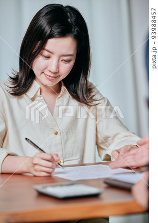 契約書にサインをする若い女性 契約書にサインをする若い女性 93988457