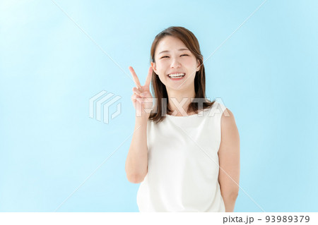 ピースする女性 ブルーバック ピースする女性 ブルーバック 93989379