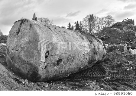 Excavated earth tank for oil and gasoline next to a hill with construction debris and excavated soil 93991060