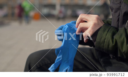Man putting on protective gloves 93991712