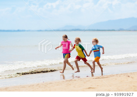 Kids playing on beach. Children play at sea. 93991927