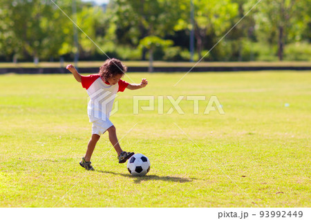 Cute curly little boy playing football. Kids play. 93992449