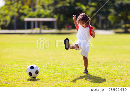 Cute curly little boy playing football. Kids play. 93992450