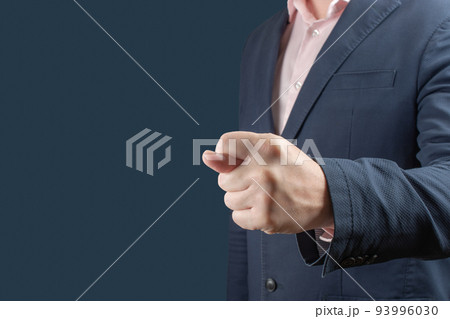 businessman shows fig gesture. . Businessman in a blue suit shows a fig sign on blue background. gesture of contempt or rejection 93996030