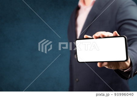 Businessman shows cell phone with blank screen in vertical position. Mock up cell mobile smart phone. Businessman shows cell phone with blank screen in vertical position. Mock up cell mobile smart phone. 93996040