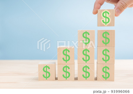 Hand of men arranging Wood block cubic stacking step up with green Dollar Sign Blue Tone. Business growth success process. Up Trend. Wooden block and dollar mark 93996066