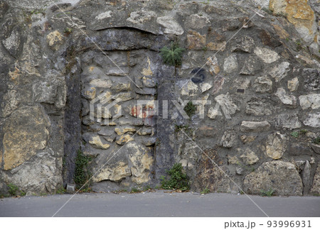 A stone building with a bricked-up door 93996931