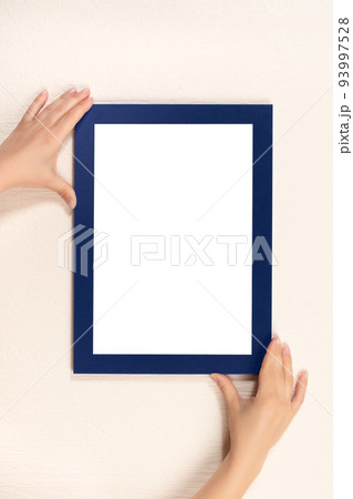 mockup diploma. woman hanging photo frame mockup on wall. White frame mockup. vertical mockup diploma. woman hanging photo frame mockup on wall. White frame mockup. vertical 93997528