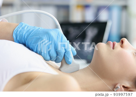 Woman receives ultrasound of thyroid gland from doctor Woman receives ultrasound of thyroid gland from doctor 93997597