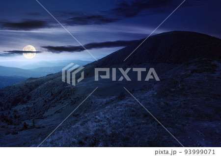view in to the mountain valley at night. beautiful summer landscape of trascarpathia with forested hills and grassy alpine meadows in full moon light view in to the mountain valley at night. beautiful summer landscape of trascarpathia with forested hills and grassy alpine meadows in full moon light 93999071