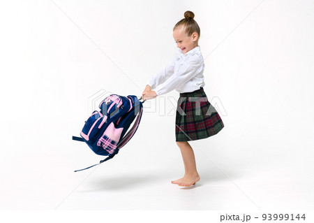 Girl spinning with a huge school backpack on a white background Girl spinning with a huge school backpack on a white background 93999144