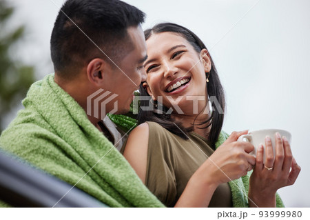 Cozy, smiling and romantic young couple cuddling and relaxing with blanket in cold winter. Loving husband and wife laughing and enjoying dating relationship bonding time in outdoors nature 93999980