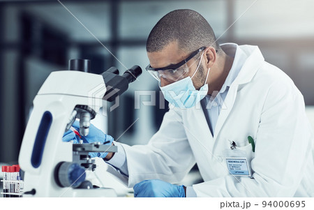 Serious young male scientist working on scientific cure for covid in a lab. Professional man in science at work during pandemic on a medical mission, thinking and vision for a vaccine for the virus. Serious young male scientist working on scientific cure for covid in a lab. Professional man in science at work during pandemic on a medical mission, thinking and vision for a vaccine for the virus. 94000695
