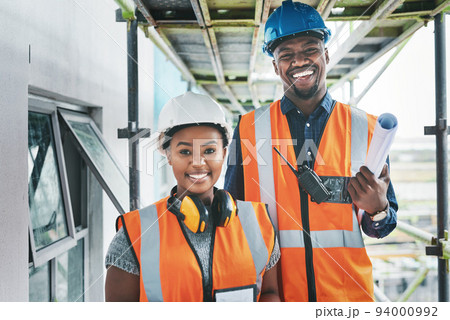 Happy and proud African American engineers at a construction site planning a building together. Portrait of young contractors standing at an apartment to be renovated for a project together Happy and proud African American engineers at a construction site planning a building together. Portrait of young contractors standing at an apartment to be renovated for a project together 94000992
