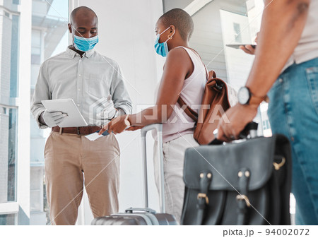 Covid security, passport and immigration at the airport during travel restrictions. Guard or compliance officer checking identity document of traveling woman in the corona virus or covid 19 pandemic Covid security, passport and immigration at the airport during travel restrictions. Guard or compliance officer checking identity document of traveling woman in the corona virus or covid 19 pandemic 94002072