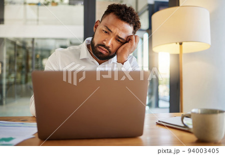 Stress, burnout and sad eyes of businessman on laptop working late on an email at house or home. Headache, mental health and disappointed worker working on finance, accounting or financial tax Stress, burnout and sad eyes of businessman on laptop working late on an email at house or home. Headache, mental health and disappointed worker working on finance, accounting or financial tax 94003405