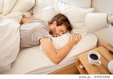 Sleeping, resting and sleepy man lying in bed with his eyes closed in a deep sleep in his bedroom. Rest, relax and tired person at home dreaming and relaxing at his house taking a late morning nap Sleeping, resting and sleepy man lying in bed with his eyes closed in a deep sleep in his bedroom. Rest, relax and tired person at home dreaming and relaxing at his house taking a late morning nap 94003886
