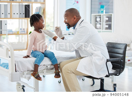 Doctor, mouth of child and black man helping little girl in checkup or consultation at a hospital. Medical male expert or pediatrician examining kid for throat infection, illness or sore in clinic. 94005148