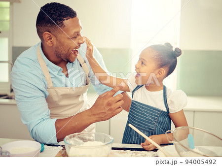 Father, playing and girl baking in family kitchen with flour, food and dough while learning to bake cake. Happy dad teaching playful daughter cookies recipe with excited young kid helping at home 94005492