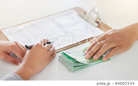 .Hand giving money, cash or bribe to a corporate finance lawyer writing on legal papers in a office. Customer handing company business man dollar payment for financial tax, audit or contract deal. 94005534