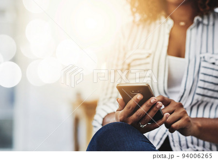 Closeup of woman hands holding, typing and using a phone to browse the internet. Young casual female on smartphone texting, messaging and chatting with friends on social networks. 94006265