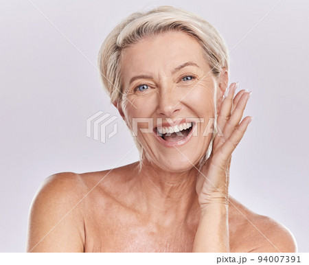 Portrait of a happy woman showing healthy skin with smile, advertising beauty skin care cosmetics and health wellness on grey studio background. Portrait of face of senior model doing self care 94007391