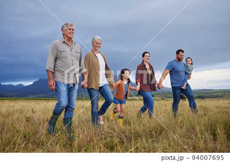 Big happy family walking on field, meadow and countryside in nature to relax, bond and holding hands in love, trust and support. Generation of grandparents, parents and kids having fun outside Big happy family walking on field, meadow and countryside in nature to relax, bond and holding hands in love, trust and support. Generation of grandparents, parents and kids having fun outside 94007695