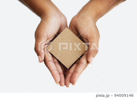 Closeup of the hands of a person showing a message, advertising a product or holding an empty paper or a cardboard card against a white background. Top view of woman promoting an item or sign 94009146