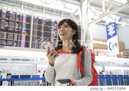 空港内でスマホを操作するバックパッカー女性 94012804