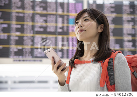 空港内でスマホを操作するバックパッカー女性 94012806