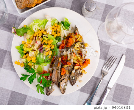 Appetizing fried blue whiting with vegetables Appetizing fried blue whiting with vegetables 94016331