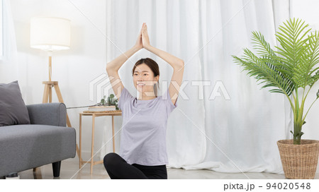 Beautiful Asian woman in sportswear is warming up or doing light exercises in the house with dumbbells and a protein shake or bottle of water and using a laptop at home, Healthy exercise. Beautiful Asian woman in sportswear is warming up or doing light exercises in the house with dumbbells and a protein shake or bottle of water and using a laptop at home, Healthy exercise. 94020548