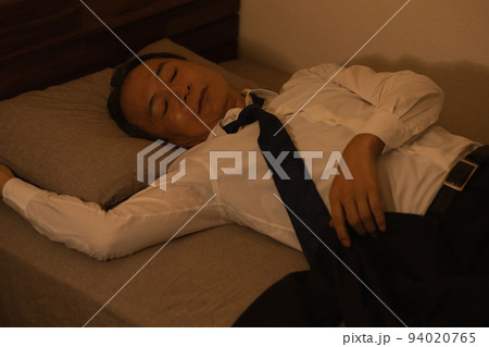 スーツのまま寝る中年男性・酔っ払いの男性イメージ 94020765