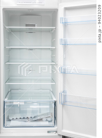 Opened empty refrigerator. Refrigerator open empty fridge inside interior. close up on empty fridge with door open. New clean refrigerator. 94023209