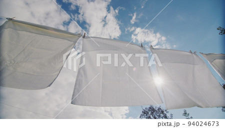 White bedding drying on a rope in the sun White bedding drying on a rope in the sun 94024673