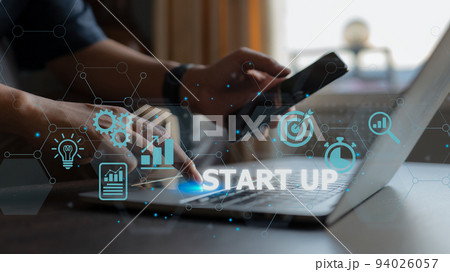 Start-up concept with icons for business and network connection on a modern virtual interface from a laptop computer. The man is putting his finger on the laptop. 94026057