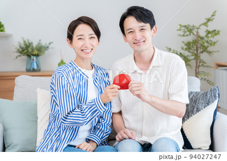 財布を持つ夫婦（お金・貯金・カップル） 94027247