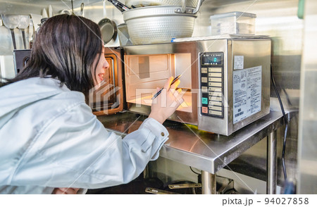 厨房を確認する若い女性のイメージカット　オーブンレンジ 94027858