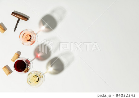 Flat-lay of red, rose and white wine in glasses on white background, copy space Flat-lay of red, rose and white wine in glasses on white background, copy space 94032343