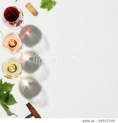 Flat-lay of red, rose and white wine in glasses on white background, copy space 94032344