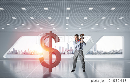 Determined banker man in modern office interior breaking dollar figure Determined banker man in modern office interior breaking dollar figure 94032413
