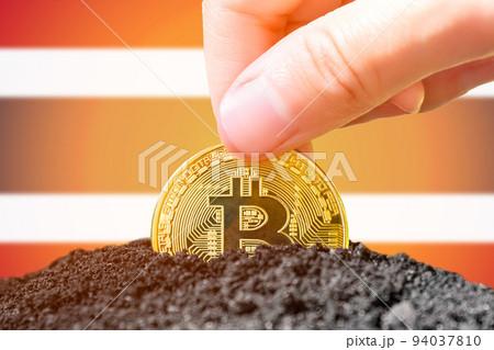 Legalization of bitcoins in Thailand. Planting a Bitcoin in the ground on the background of the flag of Thailand. Thailand - investment in cryptocurrency.  94037810
