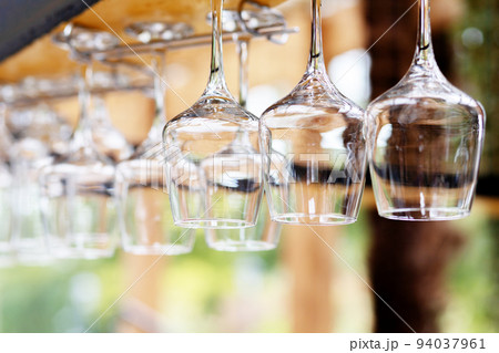 Upside down wine glasses hanging on the counter in the bar. Selective focus. Upside down wine glasses hanging on the counter in the bar. Selective focus. 94037961