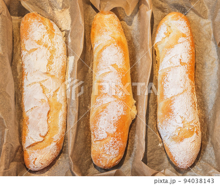 Three fresh loaves of bread on a baking sheet. Three fresh loaves of bread on a baking sheet. 94038143
