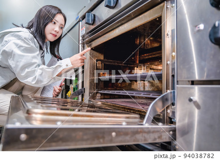 厨房を確認する若い女性　ガスオーブン 94038782