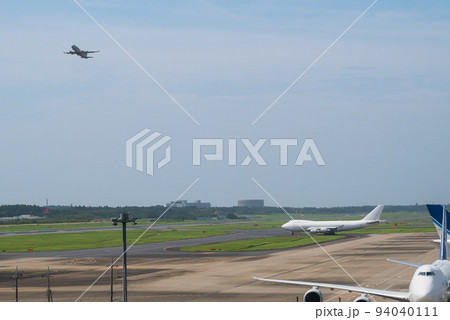 成田空港の滑走路から飛び立つ旅客機と離陸準備に入る白いジャンボ貨物機 94040111