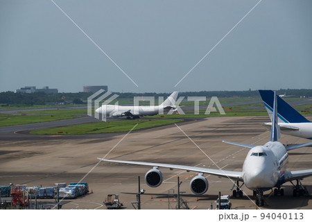 成田空港の滑走路で離陸準備に入る白いジャンボ貨物機と待機ジャンボ貨物機 成田空港の滑走路で離陸準備に入る白いジャンボ貨物機と待機ジャンボ貨物機 94040113