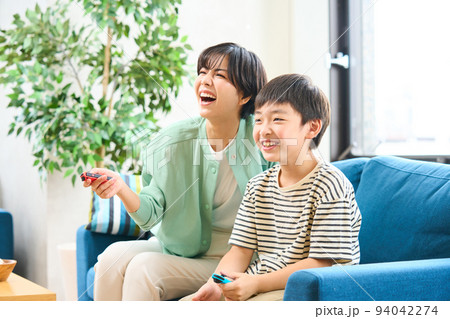 ソファーに座りゲームをする親子　母親と息子 94042274