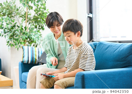 ソファーに座りゲームをする親子　母親と息子 94042350