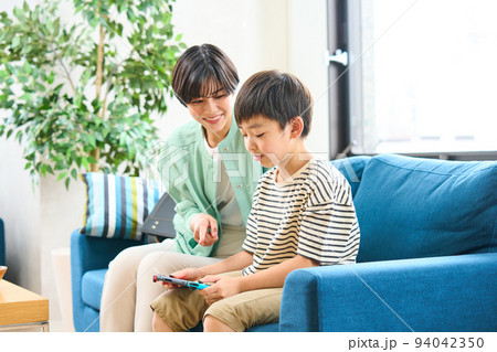 ソファーに座りゲームをする親子 母親と息子 ソファーに座りゲームをする親子 母親と息子 94042350